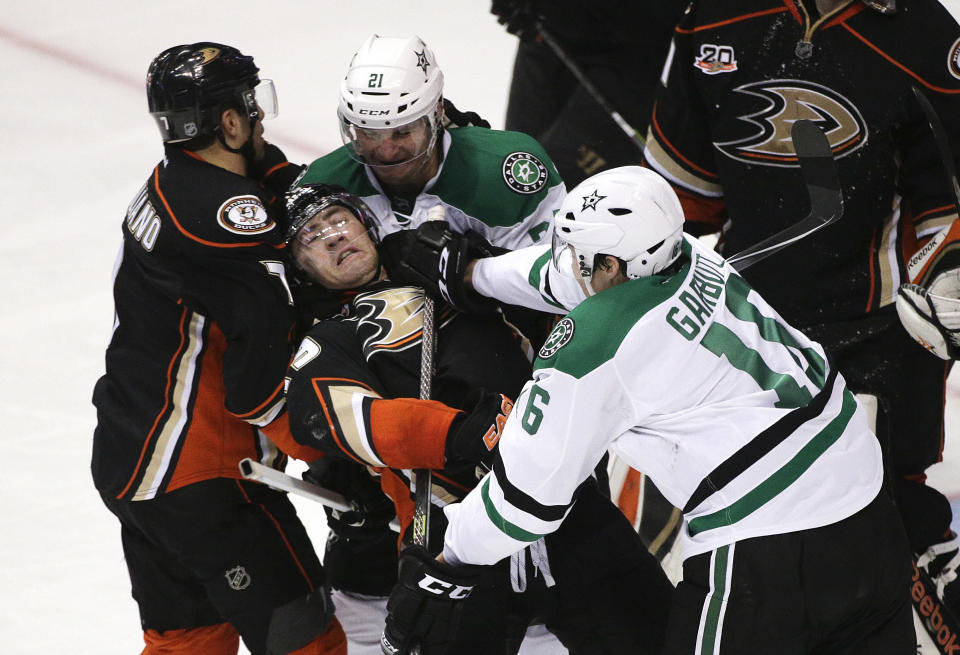 Anaheim Ducks' Stephane Robidas, center, is shoved by Dallas Stars' Ryan Garbutt, right, during the second period in Game 1 of the first-round NHL hockey Stanley Cup playoff series on Wednesday, April 16, 2014, in Anaheim, Calif. (AP Photo/Jae C. Hong)