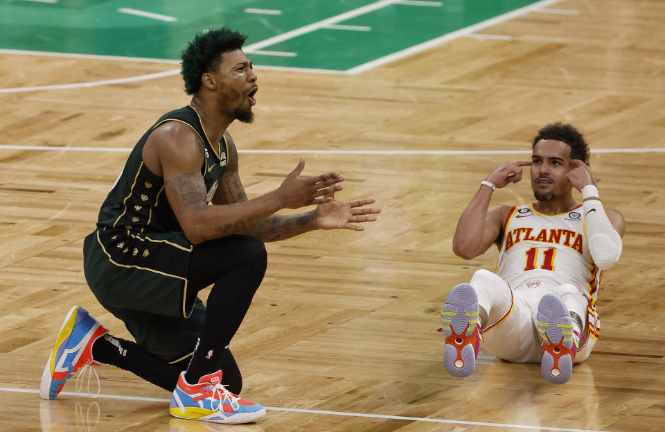 A estrela do Atlanta Hawks, Trae Young, acena com a cabeça enquanto o armador do Boston Celtics, Marcus Smart, discute uma ligação no final do jogo 5 da série do primeiro turno.  (Winslow Townson/USA Today Sports)