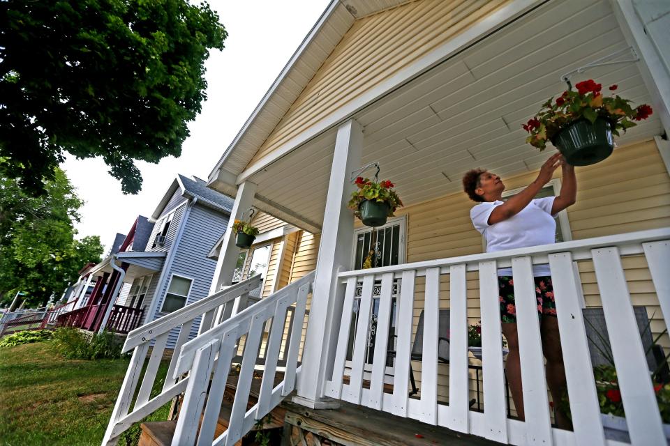 Delisa Scott prunes potted flowers on her porch in the 2000 block of N. 25th Street. Children who live in 53205, a predominately Black ZIP code on Milwaukee’s near north side, visit the emergency department for asthma 20 times more than children living just a 15-minute drive away in the predominately white suburb of Whitefish Bay.