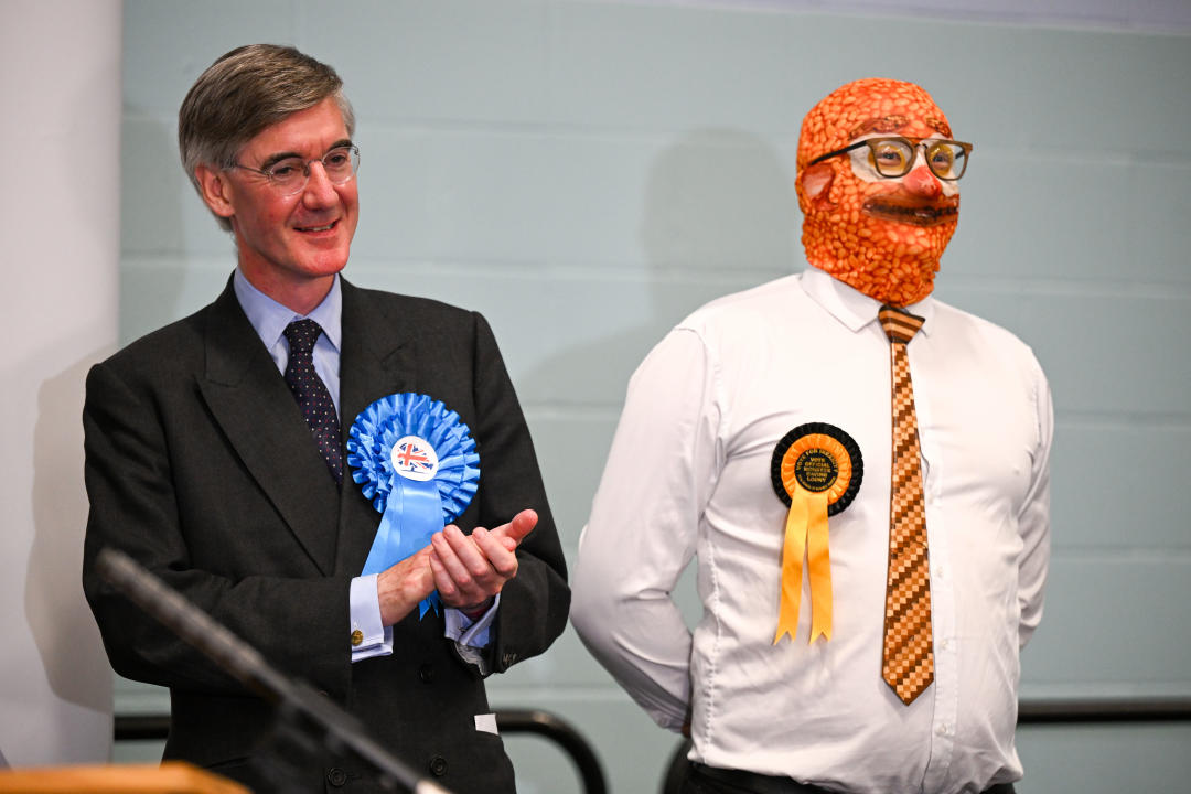 BATH, ENGLAND - JULY 05: Conservative candidate Jacob Rees-Mogg stands next to Barmy Brunch from The Official Monster Raving Loony Party during the declaration for the North East Somerset constituency at the University of Bath campus, on July 05, 2024 in Bath, England. The incumbent MP for North East Somerset is the Conservative Jacob Rees-Mogg. In Boris Johnson's government, he held the position of Secretary of State for Business, Energy and Industrial Strategy. (Photo by Finnbarr Webster/Getty Images)