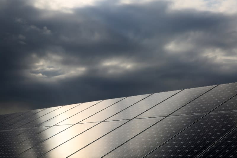 FILE PHOTO: The sun is reflected on solar panels which produce renewable energy, on the island of Eigg, Inner Hebrides, Scotland