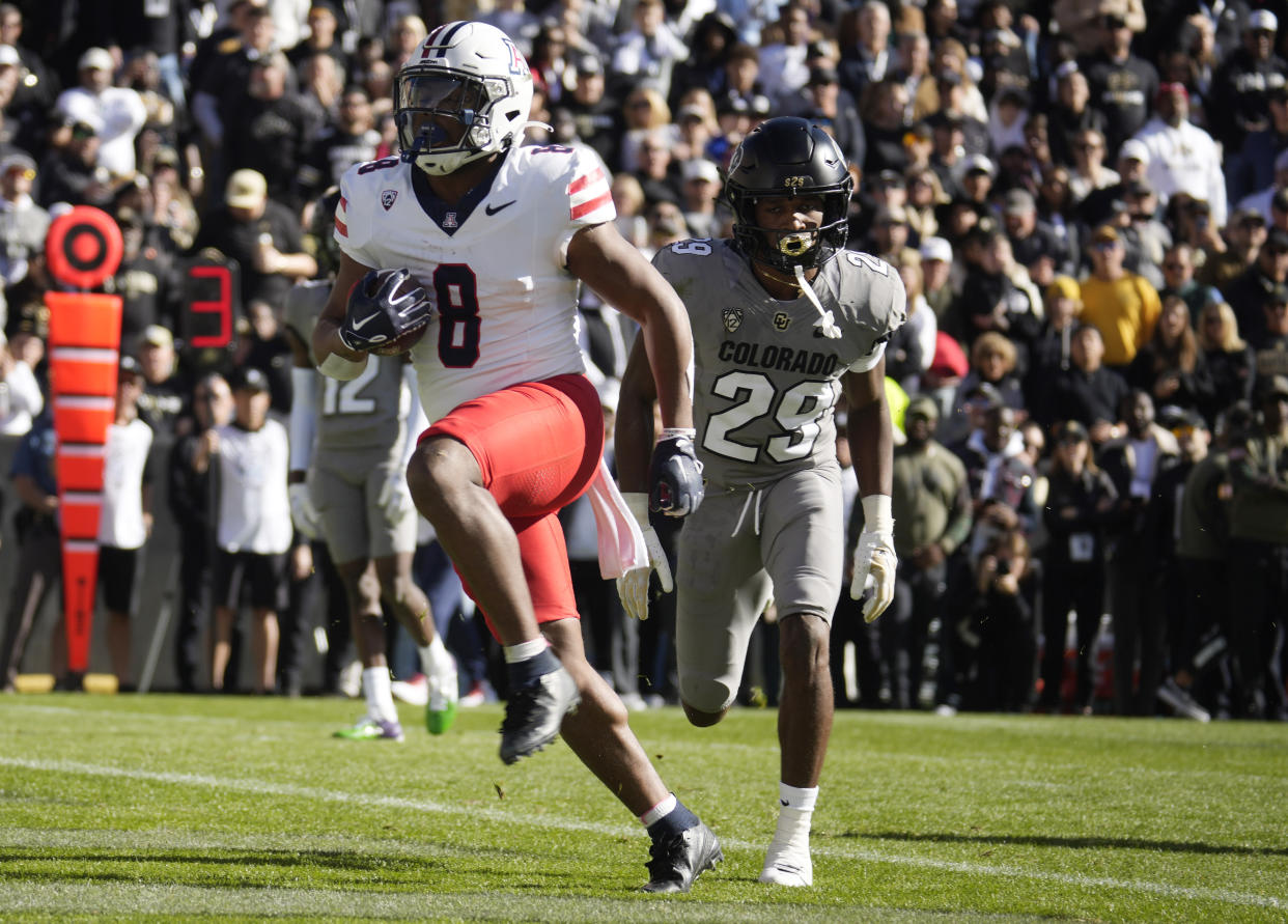 Arizona running back DJ Williams, front, runs for a touchdown past Colorado safety Rodrick Ward in the first half of an NCAA college football game on Saturday, Nov. 11, 2023, in Boulder, Colo. (AP Photo/David Zalubowski)