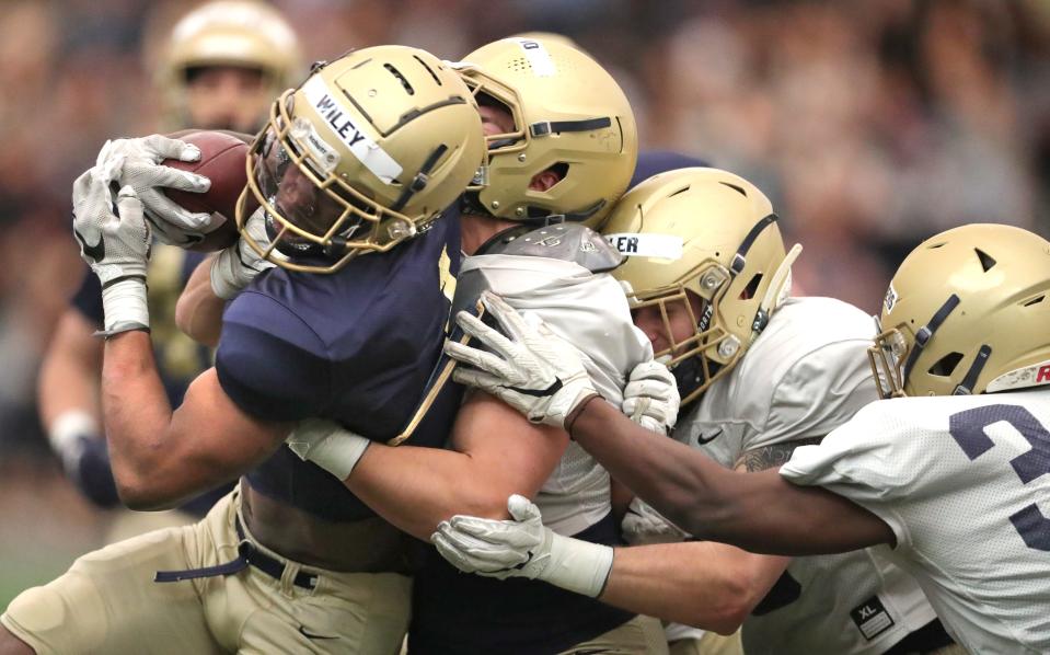 University of Akron running back Cam Wiley is stuffed by the defense during the team's spring game on Saturday at Stile Field House. [Phil Masturzo/Beacon Journal]