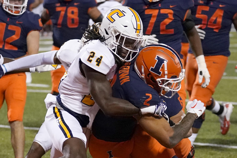 Illinois running back Chase Brown (2) carries Chattanooga defensive back Josh Battle into the end zone for a touchdown during the first half of an NCAA college football game Thursday, Sept. 22, 2022, in Champaign, Ill. (AP Photo/Charles Rex Arbogast)