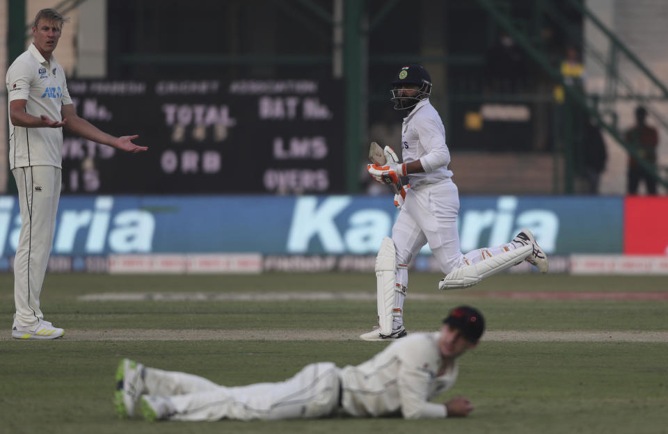 New Zealand's Kyle Jamieson, left, reacts as his teammate couldn't stop the ball while India's Ravindra Jadeja, right, takes a run during the day one of their first test cricket match with India in Kanpur, India, Thursday, Nov. 25, 2021. (AP Photo/Altaf Qadri)