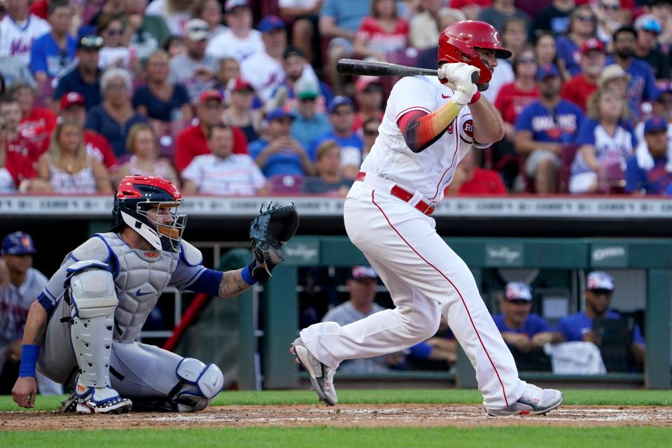 Cincinnati Reds designated hitter Mike Moustakas (9) hits a single during the second inning of a baseball game against the New York Mets, Monday, July 4, 2022, at Great American Ball Park in Cincinnati.