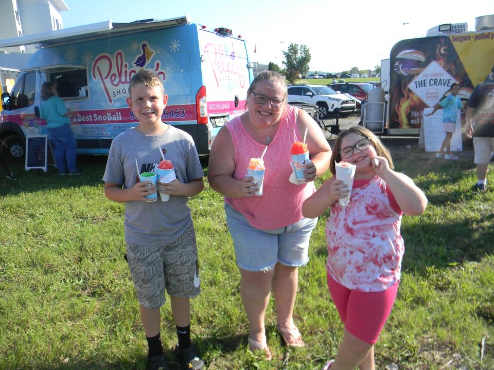 Brice Neil, from left, Michelle Pellegrin, and Sadie Pellegrin enjoy Pelican's Snowballs at the inaugural Oak Ridge Food Truck Rally.