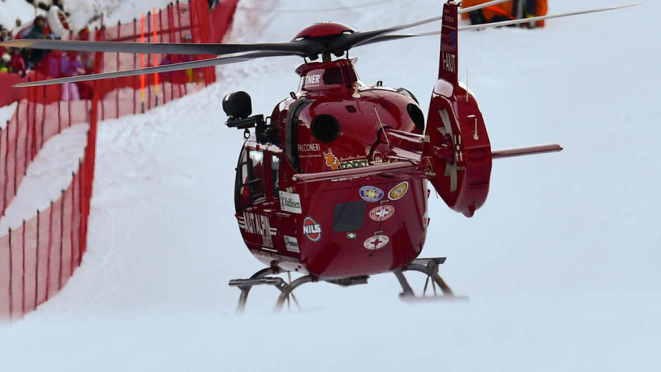 A rescuing helicopter lands on the slope. (Photo by ALBERTO PIZZOLI/AFP/Getty Images)