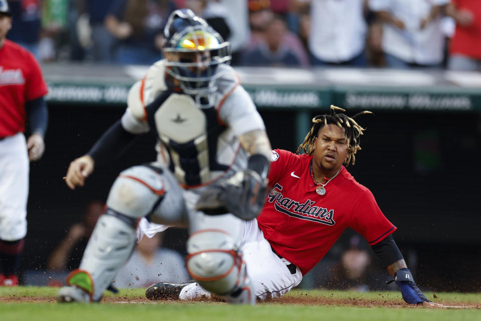 Cleveland Guardians' Jose Ramirez scores past Detroit Tigers catcher Eric Haase on a double by Oscar Gonzalez during the third inning of a baseball game Wednesday, Aug. 17, 2022, in Cleveland. (AP Photo/Ron Schwane)
