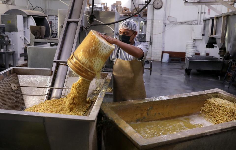 A man pours corn into a machine