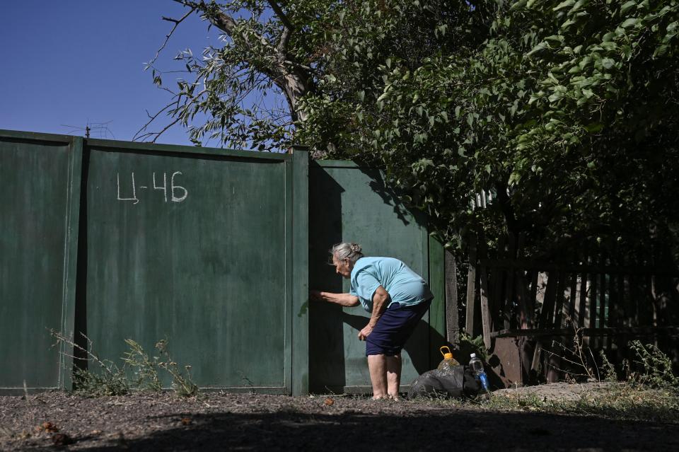 A civilian woman closes a door to her backyard during an evacuation from the outskirts of Kurakhove town (REUTERS)