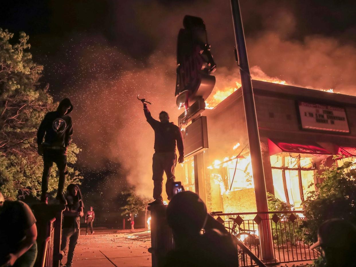 Protesters burn an Arby's fast food restaurant near the Minneapolis Police Department: EPA
