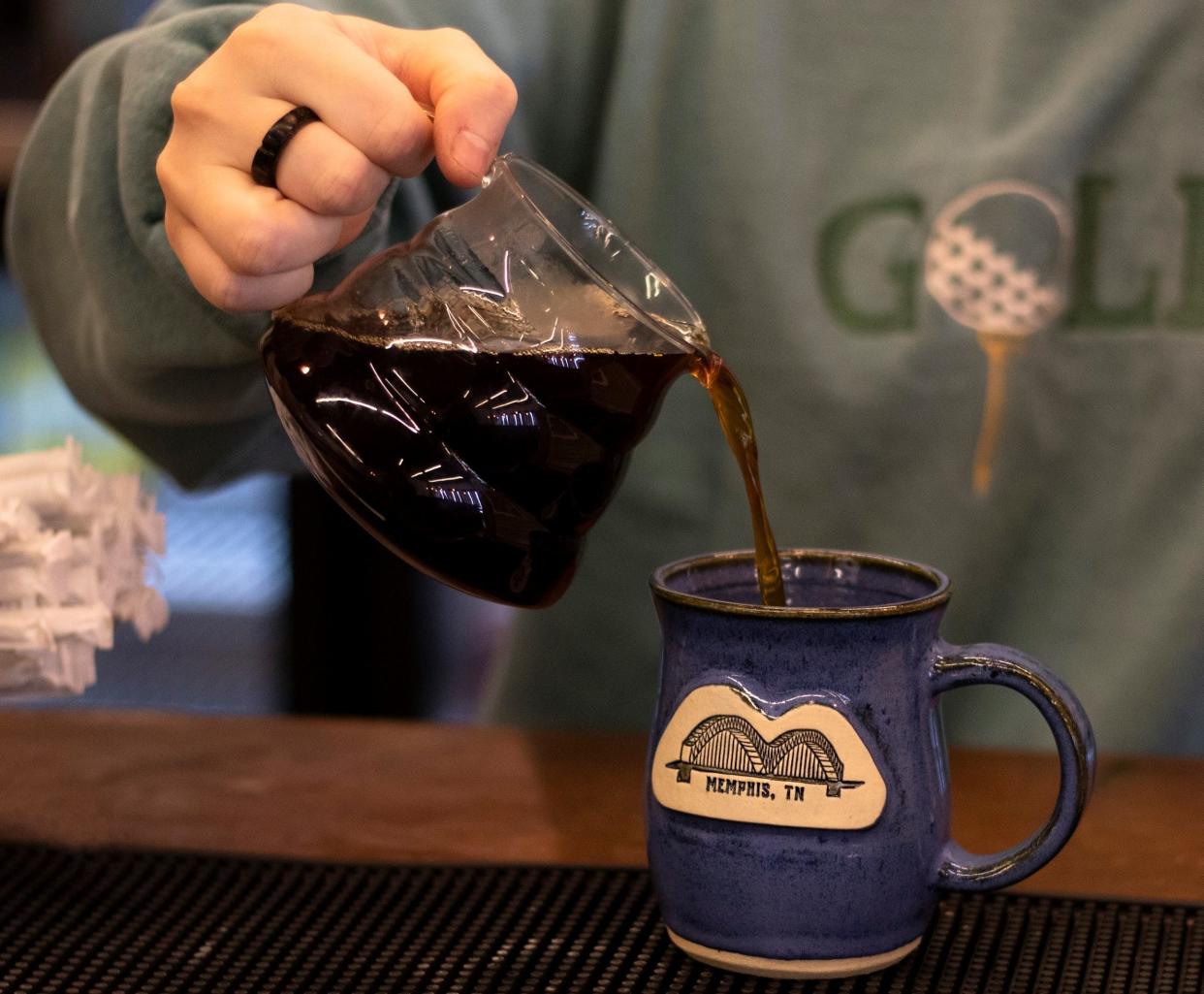 A barista at Belltower Coffeehouse and Studio in Memphis pours a cup of coffee into a mug. Belltower is known for its craft coffee drinks, creative fare, wine bar and pottery studio.