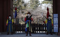 Guardias con uniformes tradicionales y mascarillas ante la entrada del palacio Deoksu en el centro de Seúl, Corea del Sur, el domingo 23 de febrero de 2020. (AP Foto/Lee Jin-man)