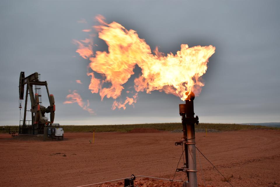 A flare burns natural gas at an oil well on Aug. 26, 2021, in Watford City, N.D. A federal report released Oct. 29, 2021, says fossil fuel extraction from federal lands produced more than 1 billion tons (918 million metric tons) of greenhouse gases the previous year.