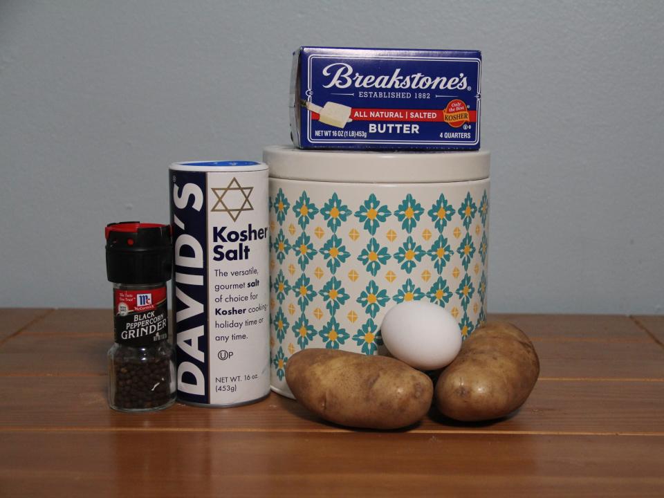 The ingredients for Ina Garten's latkes: potatoes, an egg, butter, salt, and pepper.