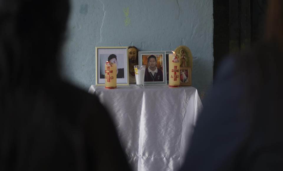 An improvised altar with the photographs of brother's Yovani and Jair Valencia Olivares, stands outside their home in San Marcos Atexquilapan, Veracruz state, Mexico, Thursday, June 30, 2022. Neighbors prayed for the brothers and a cousin who are missing after confirming that they were traveling in the abandoned trailer in San Antonio, Texas where more than 50 bodies were found. (AP Photo/Yerania Rolon)