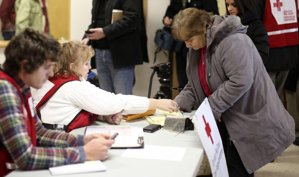 A woman fills up a form at the Red Cross table at Tobique-Plex arena in Plaster Rock