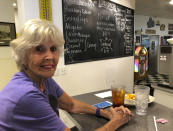 Shirley Gabhart sits at the counter at Linda's Soda Bar and Grill in Yuba City, Calif., Thursday, July 9, 2020. Sutter County was one of the first counties to reopen its economy when it defied Gov. Gavin Newsom's stay-at-home order in May to allow restaurants, hair salons, gyms and shopping malls to reopen. But Thursday, the county was added to a state watch list because of its rising number of coronavirus cases and hospitalizations. That will eventually trigger another round of restrictions, forcing bars to close and indoor operations to cease at restaurants and other public places for three weeks. Gabhart said, "it's horrible to close the restaurants because most of the county's cases stem from family gatherings and other social functions. She said she's not worried about becoming infected with the coronavirus because "God knows when I'm going to die. These politicians don't know." (AP Photo/Adam Beam)