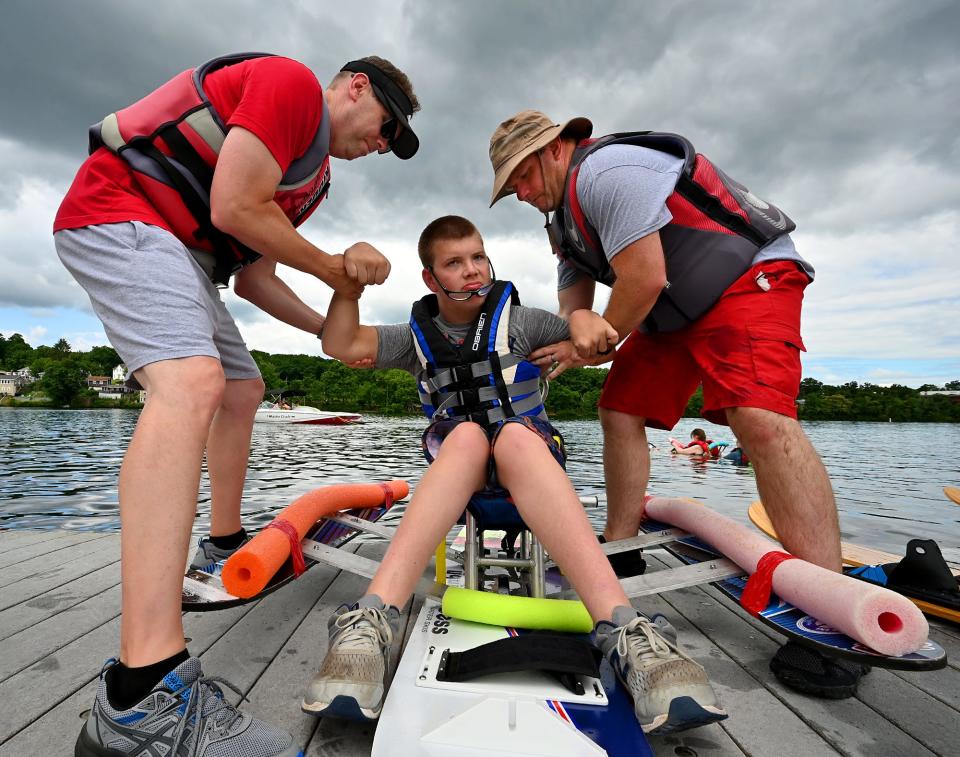 Justin Stockhaus, 22, of Webster, is helped into the special chair for water skiing by his father, Ken, left, and Ryan DesRoches of Charlton, the director of Adaptive Skiing at the Webster Water Ski Collective. The collective conducted the event Friday on Lake Quinsigamond at the Donahue Rowing Center in Shrewsbury.