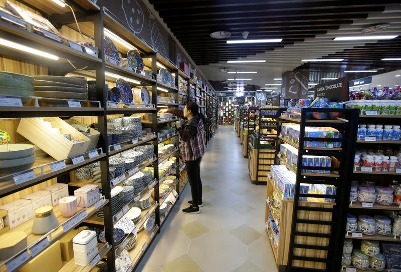 A woman selects a bowl at a supermarket in Beijing