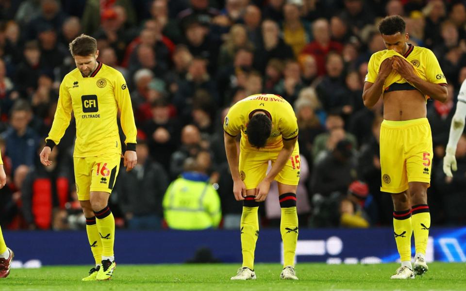 Sheffield United's Auston Trusty with teammates look dejected after Manchester United's Bruno Fernandes scores their third goal