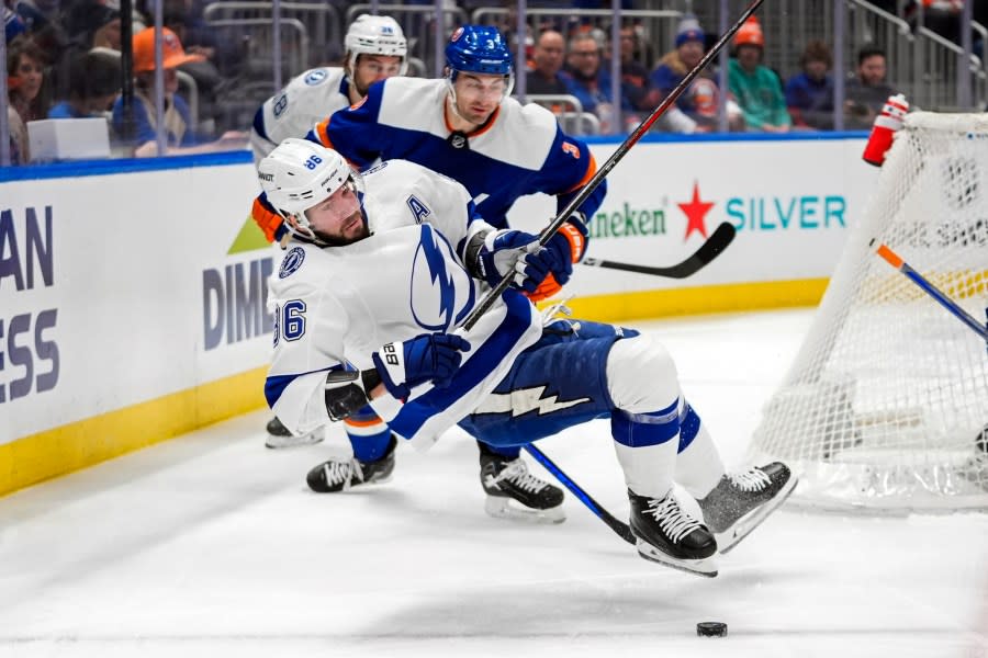 Tampa Bay Lightning’s Nikita Kucherov (86) falls down while battling for control of the puck with New York Islanders’ Adam Pelech (3) during the first period of an NHL hockey game Saturday, Feb. 24, 2024, in Elmont, N.Y. (AP Photo/Frank Franklin II)