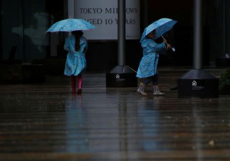 Children wearing rain suits walk in a heavy rain as Typhoon Lan approaches Japan's mainland, in Tokyo, Japan, October 22, 2017. REUTERS/Issei Kato