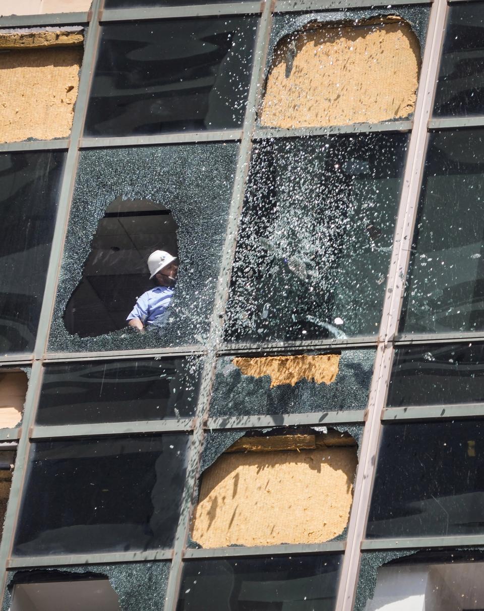 FILE - Glass falls from above as workers clean out shattered glass at the Wells Fargo building as clean up from the previous week's storm continues in downtown Houston, Monday, May 20, 2024. (Brett Coomer/Houston Chronicle via AP, file)