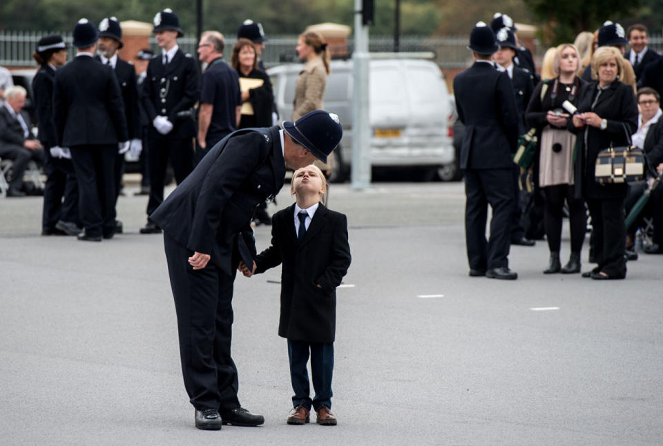 A police cadet gets a kiss from his son in Hendon, England