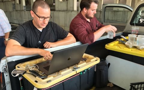 Capital Gazette reporter Chase Cook (right) and photographer Joshua McKerrow work on the next days newspaper while awaiting news from their colleagues  - Credit:  IVAN COURONNE/AFP