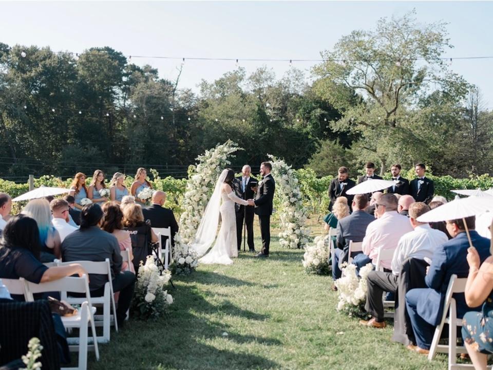 A bride and groom hold hands at their wedding altar.