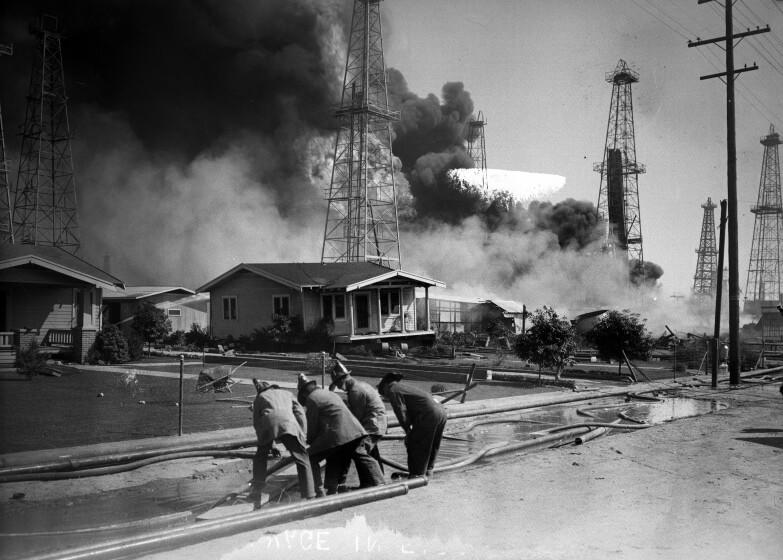 Sept. 19, 1928: Firefighters lay hoses to protect homes from an oil well fire in Santa Fe Springs. Firefighters laying hoses to protect homes from oil well fires in Santa Fe Springs, Calif. Dated Sept 19, 1928. Los Angeles Times Photographic Archive/UCLA. Image has some emulsion damage. Scanned from glass negative.