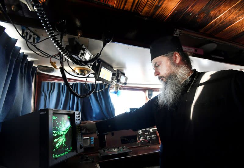 Father Abbot Abibon turns on the radar in the wheelhouse of a mobile Georgian Orthodox monastery in Vlissingen