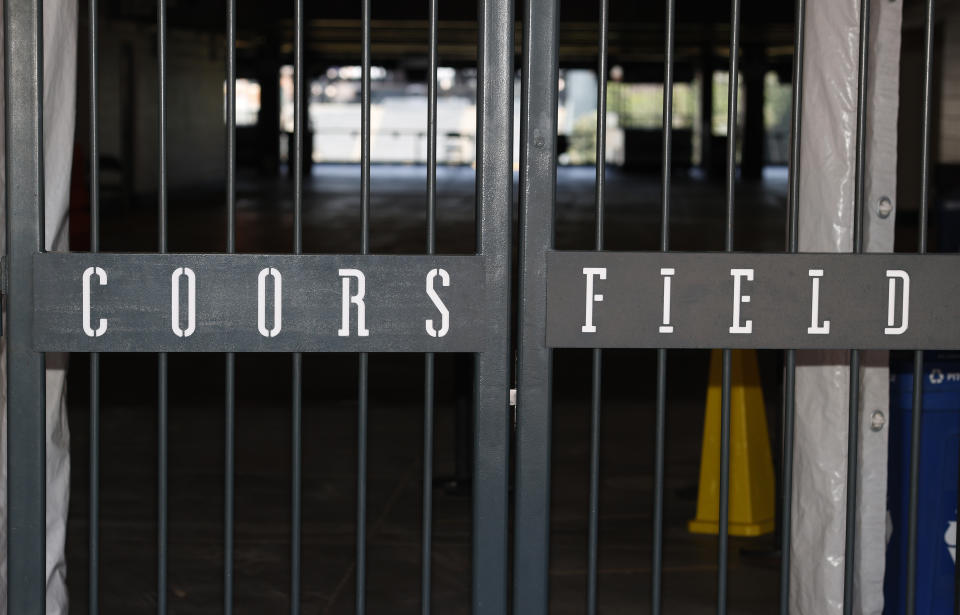 The main gate of Coors Field, home of the Major League Baseball team the Colorado Rockies, is locked early Tuesday, June 23, 2020, in Denver. The league is waiting for the players' union to respond Tuesday to whether it will agree to health protocols for a 60-game regular-season slate and if players will report for training camp by July 1. (AP Photo/David Zalubowski)