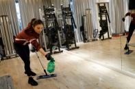 A staff member sprays disinfectant before a livestream gym class, as the country is hit by an outbreak of the new coronavirus, in Beijing