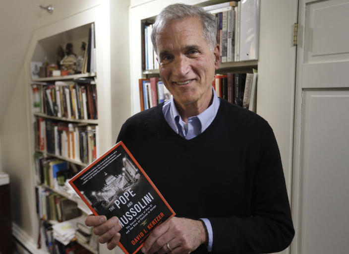 FILE - Brown University professor David I. Kertzer holds his book "The Pope and Mussolini: The Secret History of Pius XI and the Rise of Fascism in Europe" in his office, Monday, April 20, 2015, in Providence, R.I. The Vatican has long defended its World War II-era pope, Pius XII, against criticism that he remained silent as the Holocaust unfolded, insisting that he worked quietly behind the scenes to save lives. Pulitzer Prize-winning author Kertzer’s new book “The Pope at War,” which comes out Tuesday, June 7, 2022 in the United States, citing recently opened Vatican archives, suggests the lives the Vatican worked hardest to save were Jews who had converted to Catholicism or were children of Catholic-Jewish “mixed marriages.” (AP Photo/Steven Senne, File)