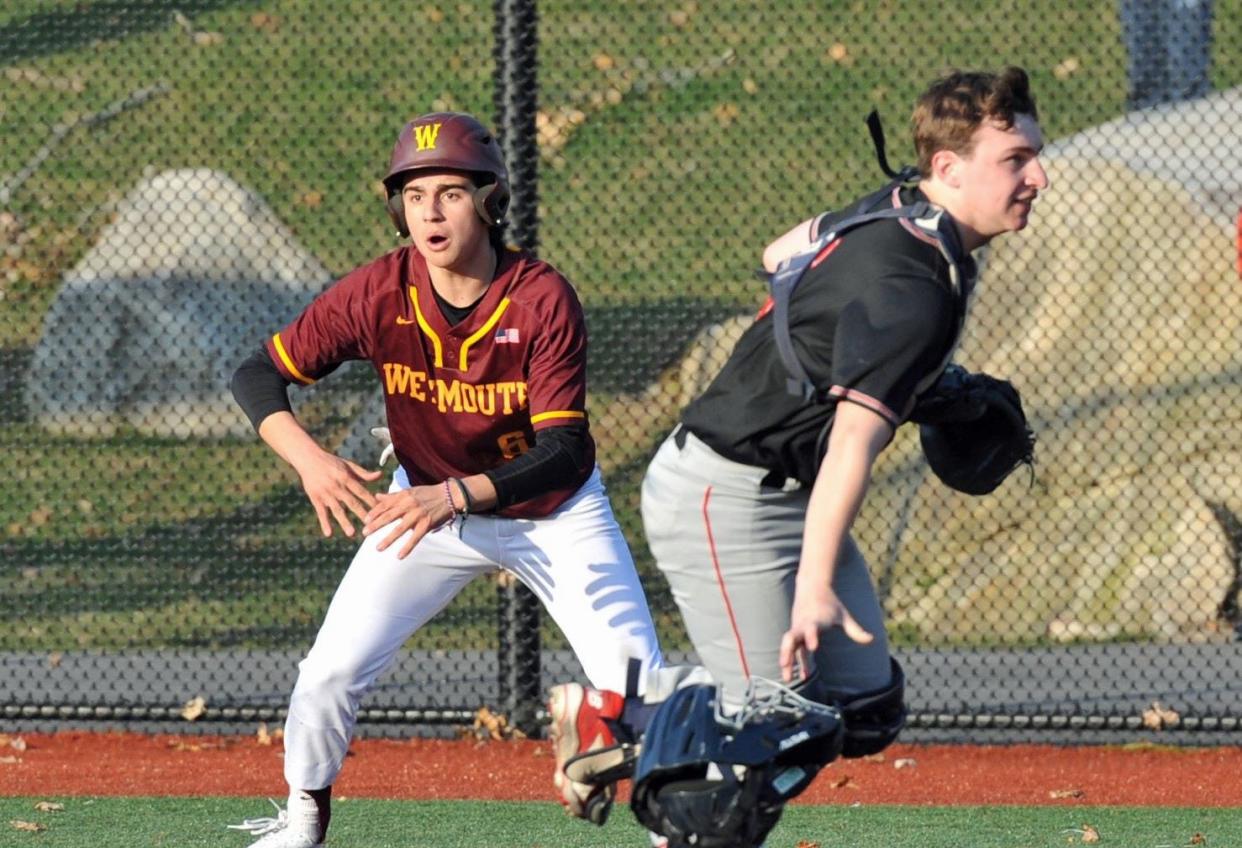 Weymouth's Jack Reyes, left, yells to teammate to slide coming into home as North Quincy catcher Max Gaudiano, right, runs after an errant throw during high school baseball at Libby Field in Weymouth, Tuesday, April 4, 2023.