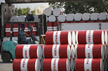 A worker unloads fuel products from a truck at a state-owned Pertamina fuel depot in Jakarta in this September 9, 2014 file photo. REUTERS/Darren Whiteside/Files
