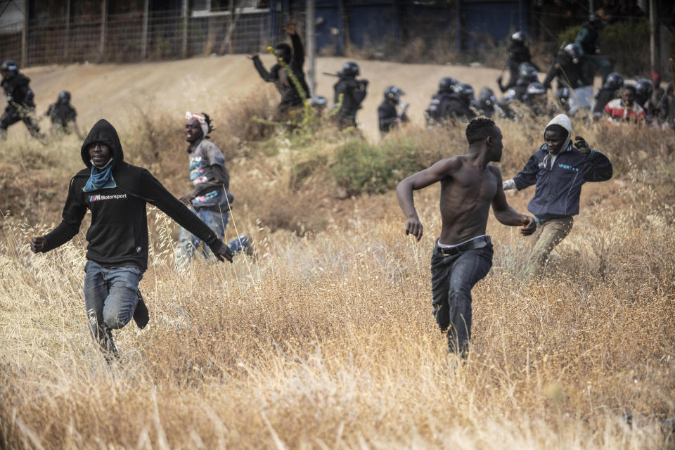 Migrants run on Spanish soil after crossing the fences separating the Spanish enclave of Melilla from Morocco in Melilla, Spain, Friday, June 24, 2022. Dozens of migrants stormed the border crossing between Morocco and the Spanish enclave city of Melilla on Friday in what is the first such incursion since Spain and Morocco mended diplomatic relations last month. (AP Photo/Javier Bernardo)