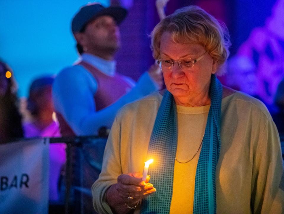 Mayor Lisa Middleton looks down at her candle while other local leaders speak during a vigil to honor the victims of the Club Q shooting in Colorado Springs on Arenas Road in Palm Springs, Calif., Sunday, Nov. 27, 2022. 