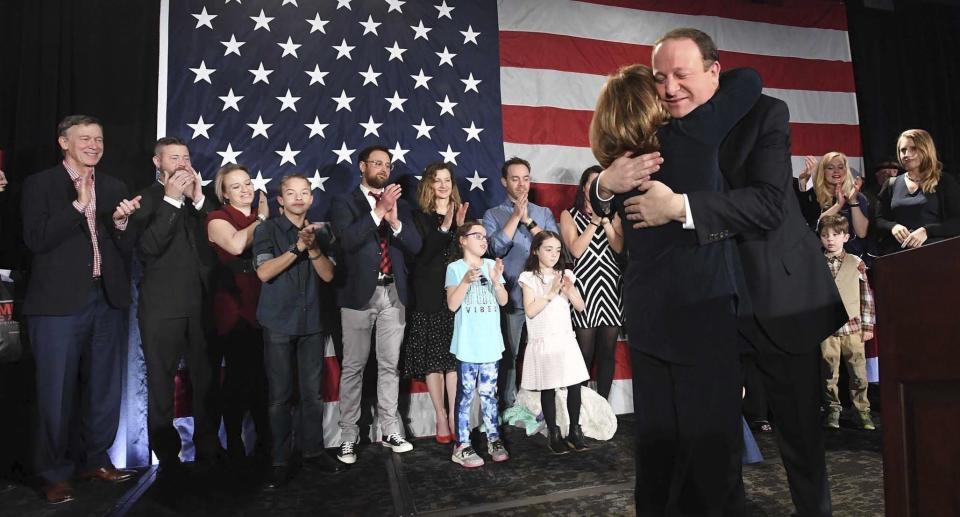 FILE - In this Tuesday, Nov. 6, 2018 file photo, Colorado Governor-elect Jared Polis hugs his Lt. Governor-elect Dianne Primavera during his victory speech at the watch party for Colorado Democrats at a hotel in downtown Denver. Polis became the first openly gay man elected as a governor of any state. (Jerilee Bennett/The Gazette via AP)