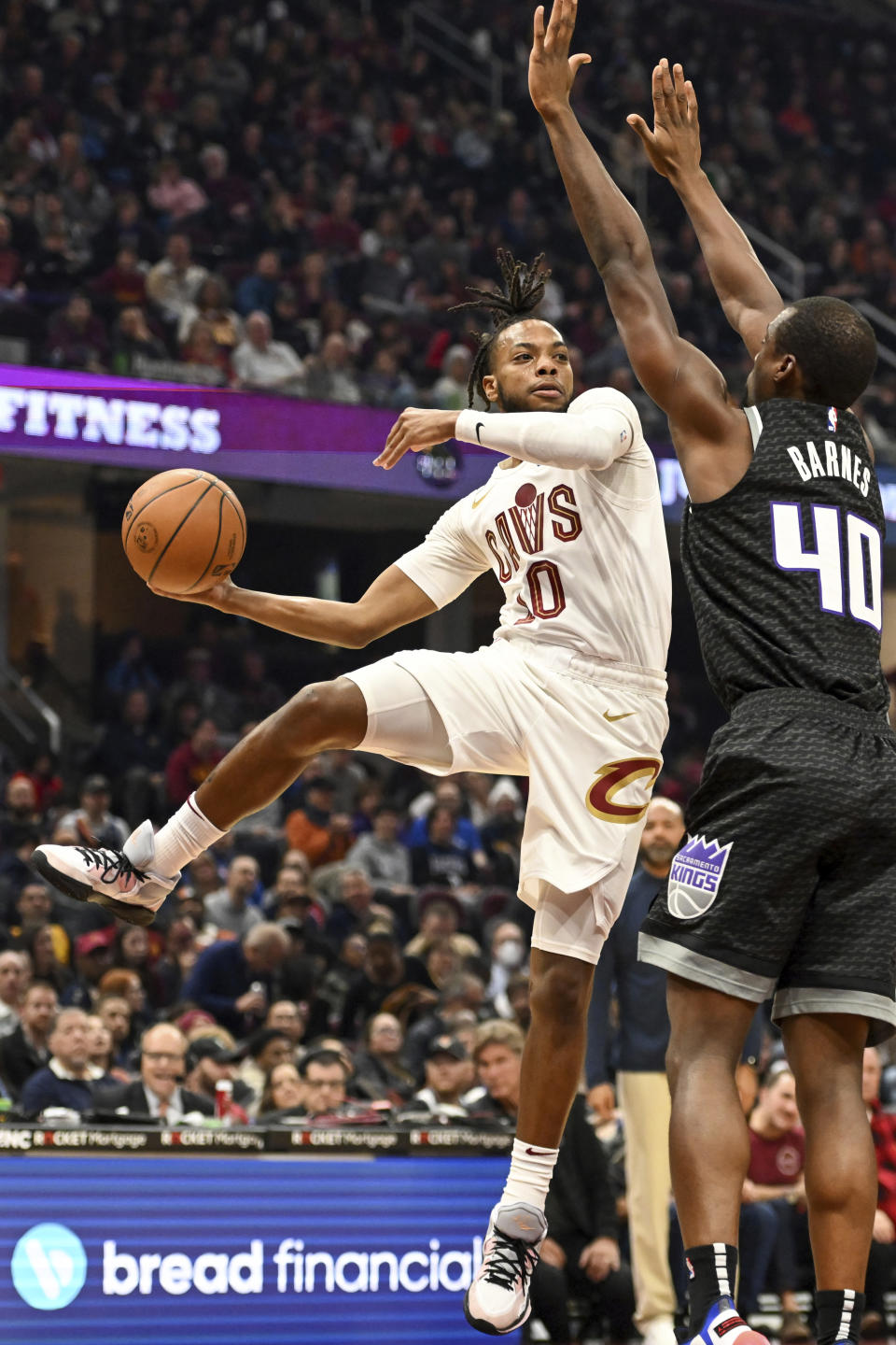 Cleveland Cavaliers guard Darius Garland (10) passes against Sacramento Kings forward Harrison Barnes (40) during the first half of an NBA basketball game, Friday, Dec. 9, 2022, in Cleveland. (AP Photo/Nick Cammett)