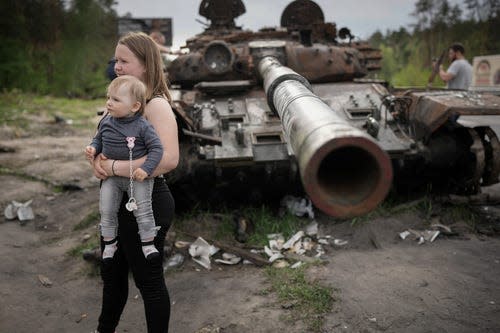 KYIV, UKRAINE - MAY 20: People driving back into Kyiv stop to take photographs of a destroyed Russian main battle tank on the main highway into the city on May 20, 2022 in Kyiv, Ukraine. As Russia concentrates its attack on the east and south of the country, residents of the Kyiv region are returning to assess the war's toll on their communities. The towns around the capital were heavily damaged following weeks of brutal war as Russia made its failed bid to take Kyiv.  (Photo by Christopher Furlong/Getty Images) ORG XMIT: 775811075 ORIG FILE ID: 1398340244