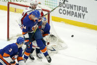 New York Islanders' Scott Mayfield (24) defends against Washington Capitals center Nicklas Backstrom (19) as Islanders goaltender Semyon Varlamov (40) makes a save during the second period of an NHL hockey game Thursday, April 22, 2021, in Uniondale, N.Y. (AP Photo/Kathy Willens)