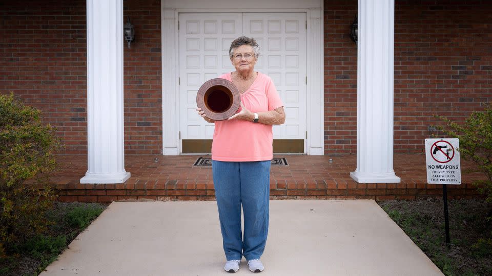 Jan Williams, who attends church with former President Jimmy Carter and taught his daughter fourth grade, poses in front of Maranatha Baptist Church in Plains with a collection plate Carter made. - Brendan Smialowski/AFP/Getty Images