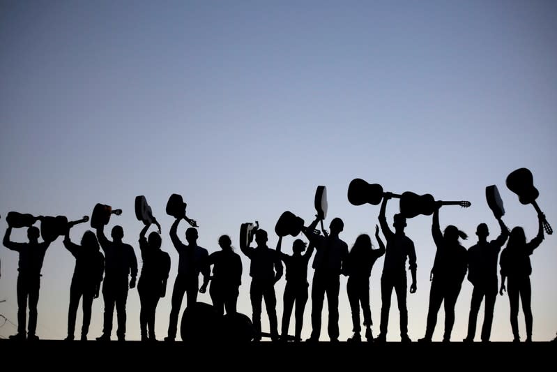 FILE PHOTO: Members of a Rondalla, an ensemble of plectrum and stringed instruments, are silhouetted while holding up their instruments after performing in Ciudad Juarez