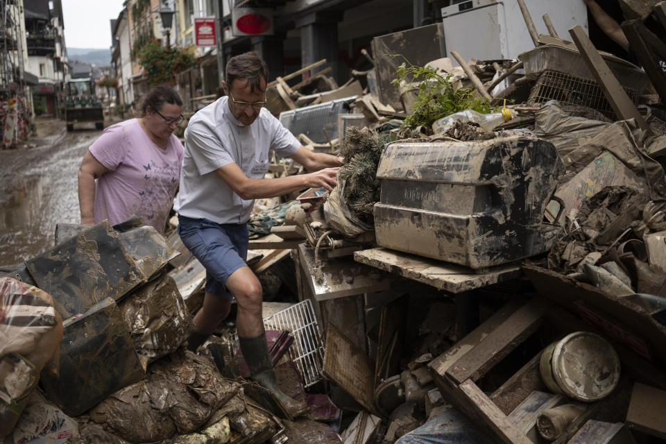 Priest Joerg Meyrer walks over debris in Bad Neuenahr-Ahrweiler, Germany, Monday July 19, 2021. More than 180 people died when heavy rainfall turned tiny streams into raging torrents across parts of western Germany and Belgium, and officials put the death toll in Ahrweiler county alone at 110. (AP Photo/Bram Janssen)