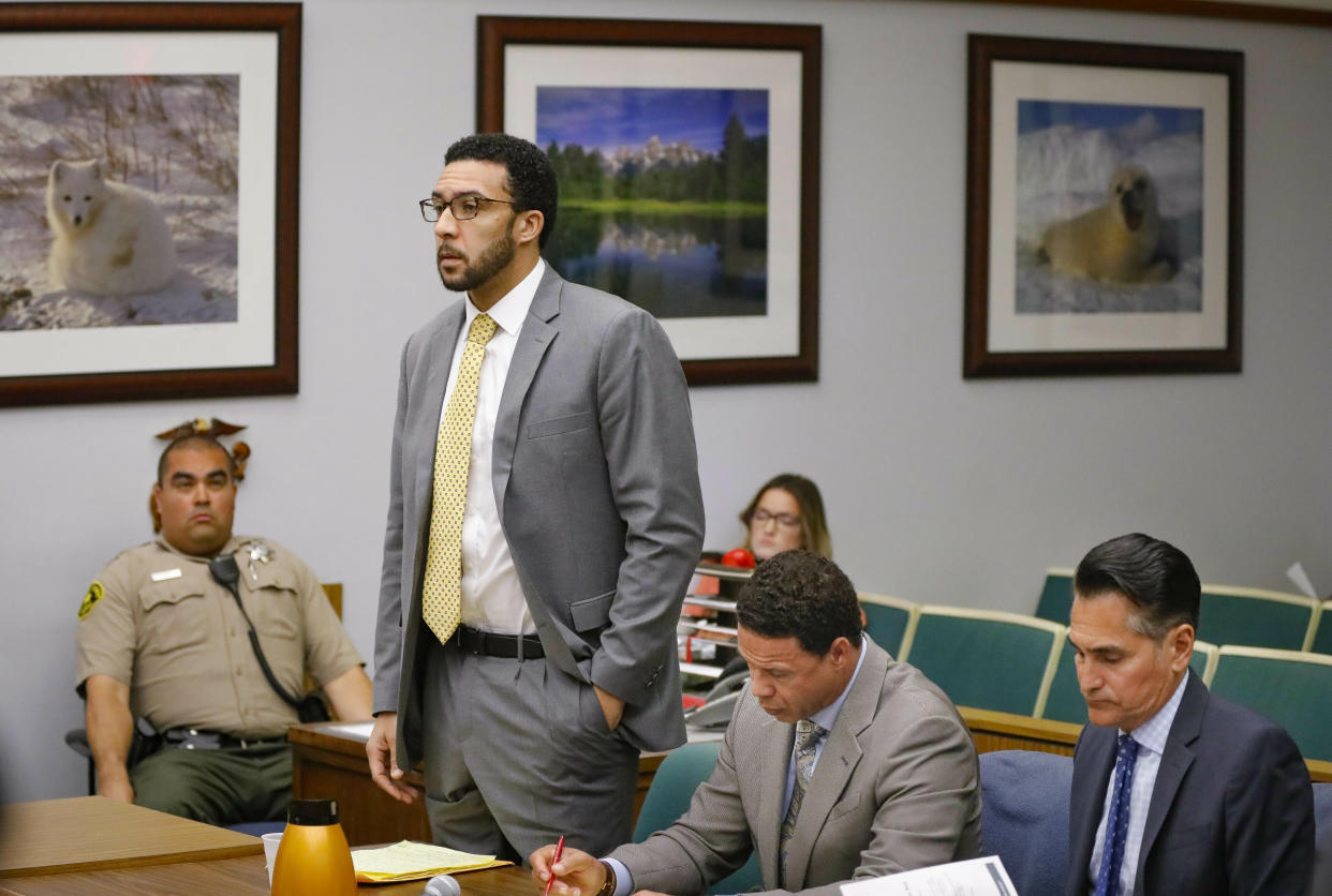 FILE - In this June 14, 2019 file photo Ex-NFL player Kellen Winslow II, standing, who was accused of committing several sex crimes against women in North County last year, including rape, answers a question from San Diego County Superior Court Vista Judge Blaine Bowman during a status hearing in Vista, Calif. Winslow could face more than a decade in prison for multiple rapes and other sexual offenses against five women in Southern California, including one who was homeless when he attacked her in 2018. Winslow will appear via video conference at the hearing Wednesday, March 3, 2021, in San Diego Superior Court. (Howard Lipin/The San Diego Union-Tribune via AP, Pool,File)