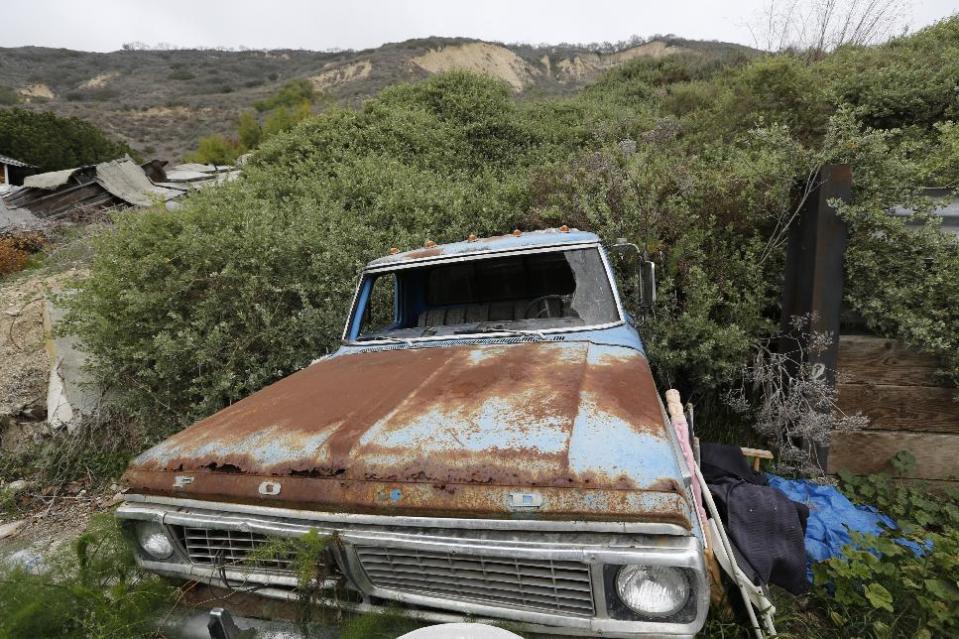 A rusted Ford pickup truck remains buried by a mudslide in the tiny coastal town of La Conchita, Calif., Monday, March, 24, 2014. As with Oso, Wash., the coastal Southern California town of La Conchita knows the sorrows that a major mudslide can unleash. In 2005, a wall of debris slammed down from a bluff soaked by winter storms, killing 10 people and damaging or destroying 36 homes. (AP Photo/Damian Dovarganes)